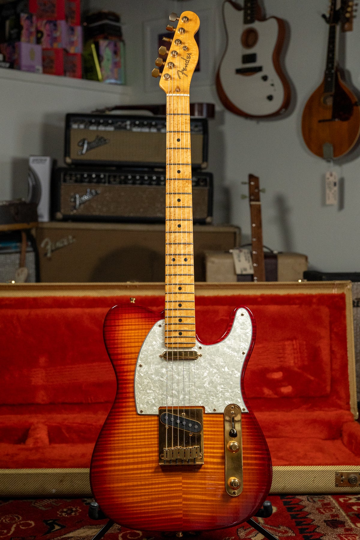 Full view of a Telecaster with a flamed sunburst finish, white pearloid pickguard, gold hardware, and a birdseye maple neck.