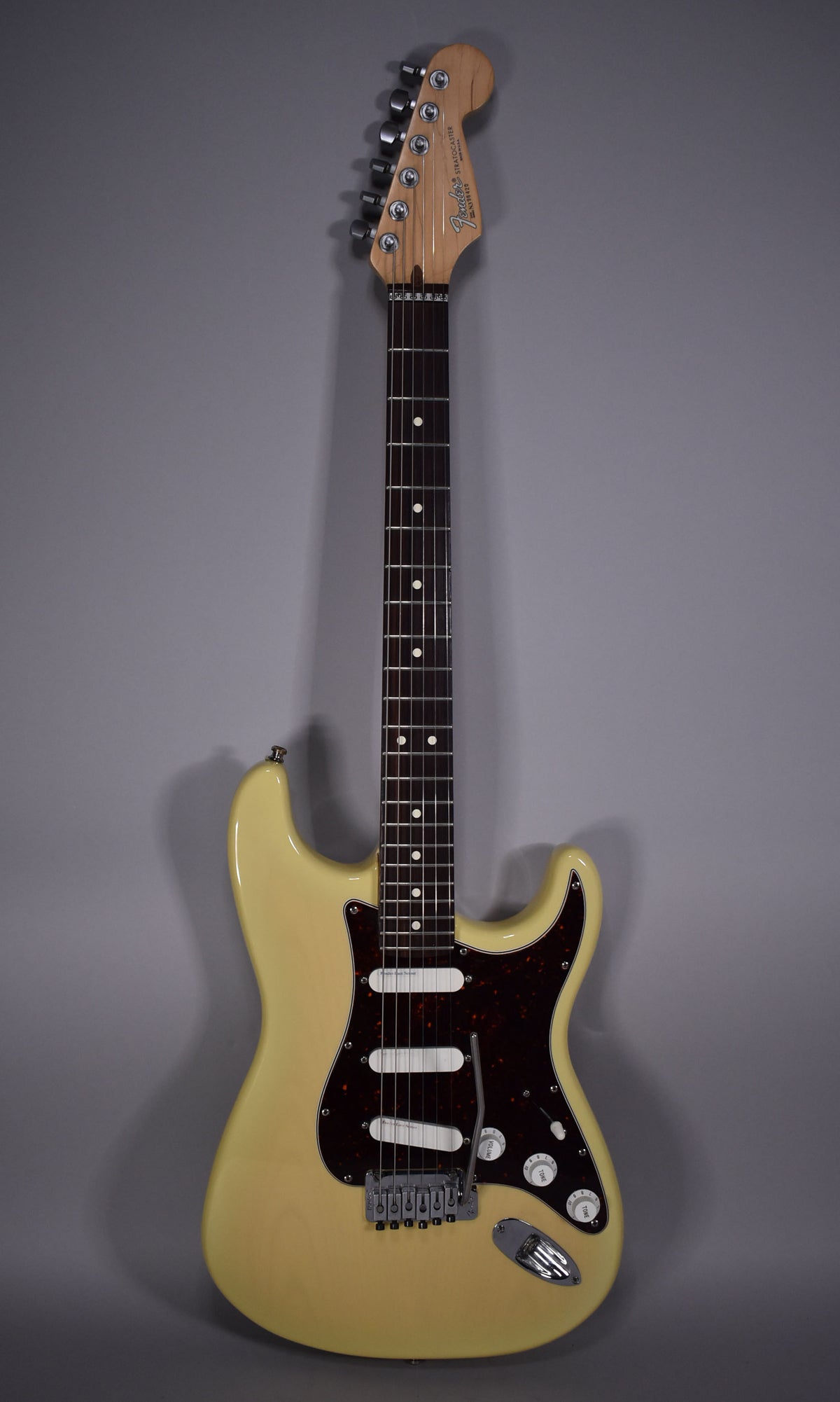 Full front view of a vintage blonde Stratocaster with a dark tortoiseshell pickguard, three white single-coil pickups, and chrome hardware.