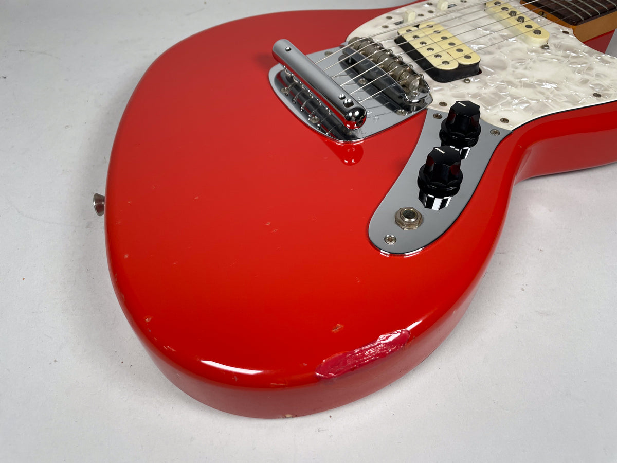 Close-up of the Fiesta Red body, showing a large chip on the lower bout, chrome control plate with two black knobs, and output jack.