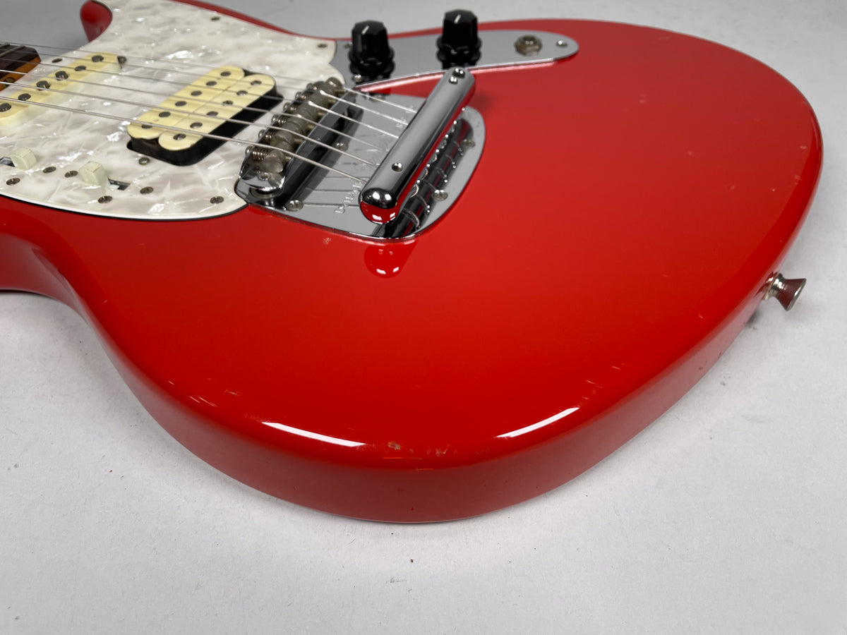 The Fiesta Red guitar body is angled, showing the pearloid pickguard, cream pickups, chrome bridge, and some small dings.