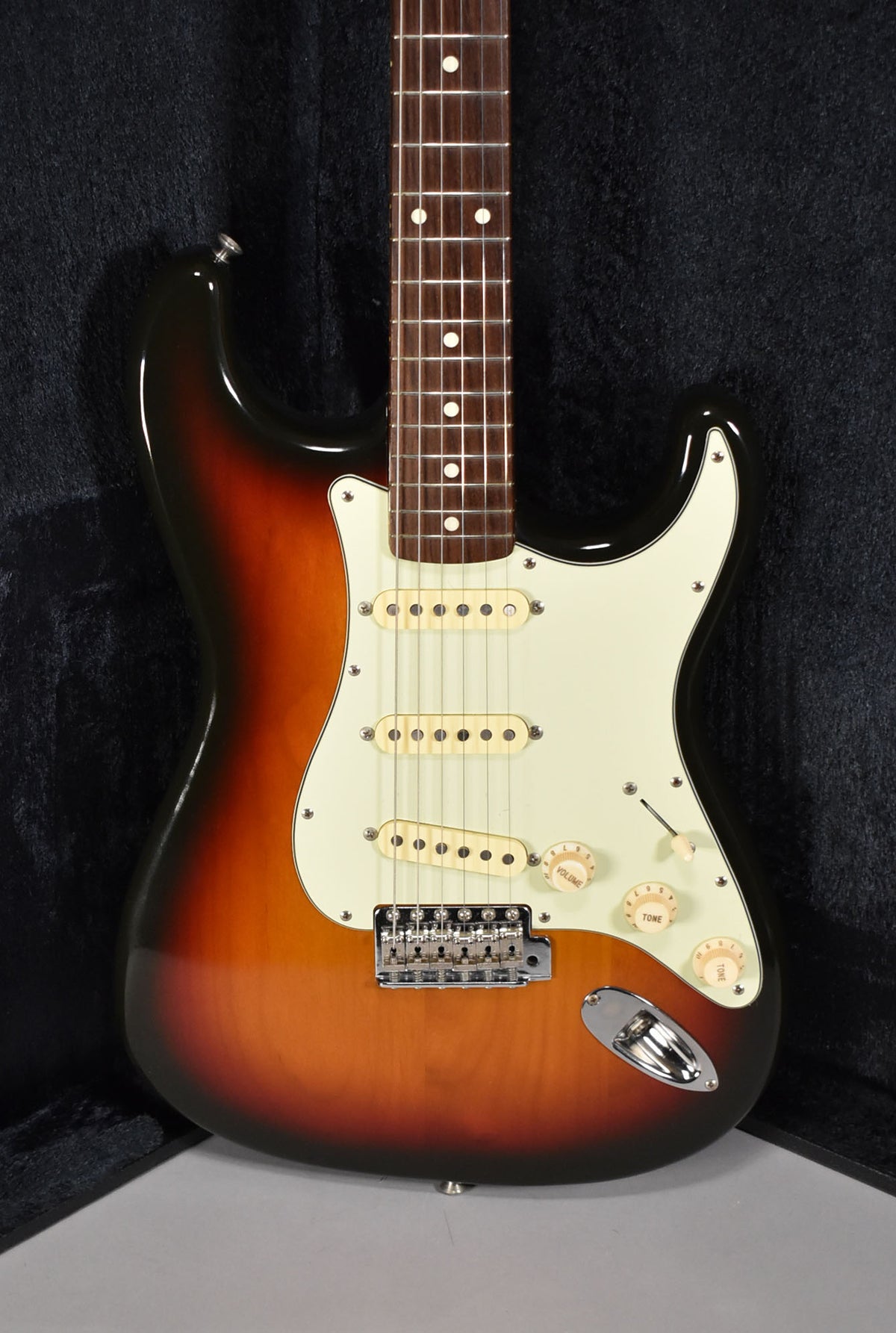 Full front view of a sunburst Stratocaster with a cream pickguard, three single-coil pickups, and three cream control knobs.
