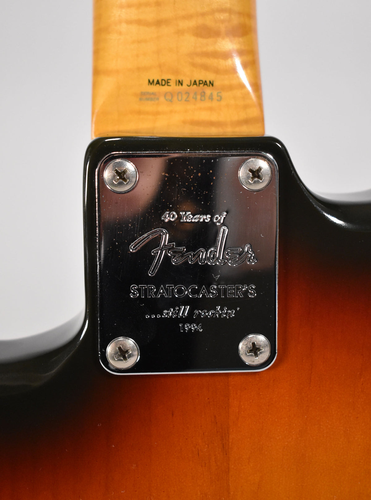 Close-up of the neck joint, showing a chrome 4-bolt neck plate with "40 Years of Fender Stratocaster's ...still rockin' 1994" engraving.