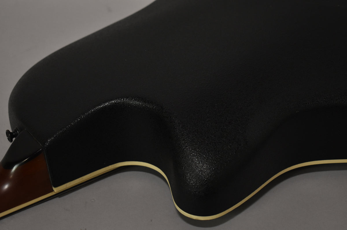 Close-up of the guitar's textured black Lyrachord bowl back, showing the cutaway and cream binding, with the neck heel visible.