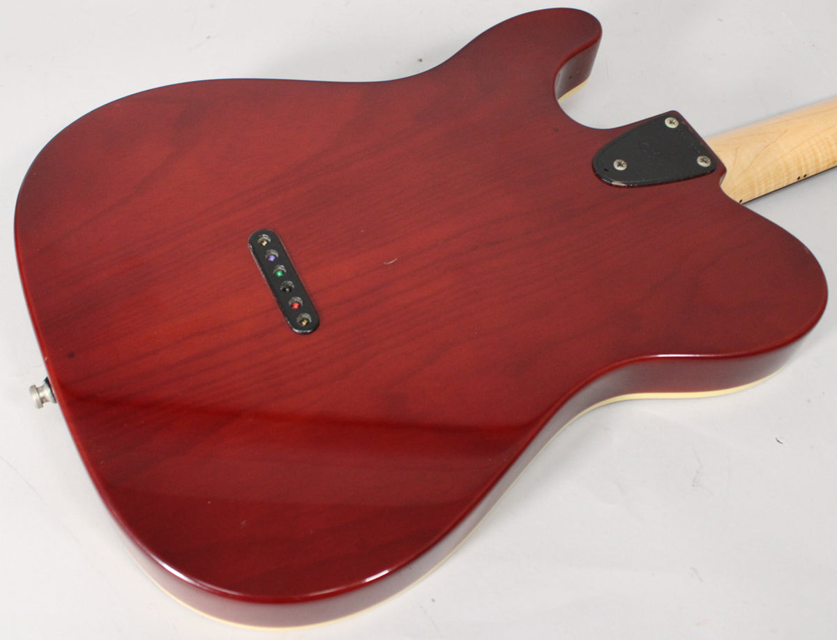 The back of the sunburst guitar body, showing the string-through-body ferrules, neck plate, and a few minor surface scratches.