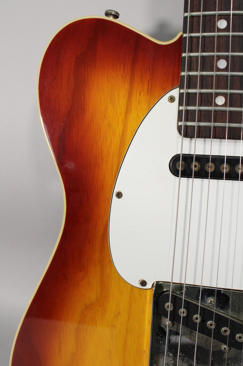 Close-up of the sunburst body, white pickguard, and neck with dot inlays, showing wear on the bridge pickup.