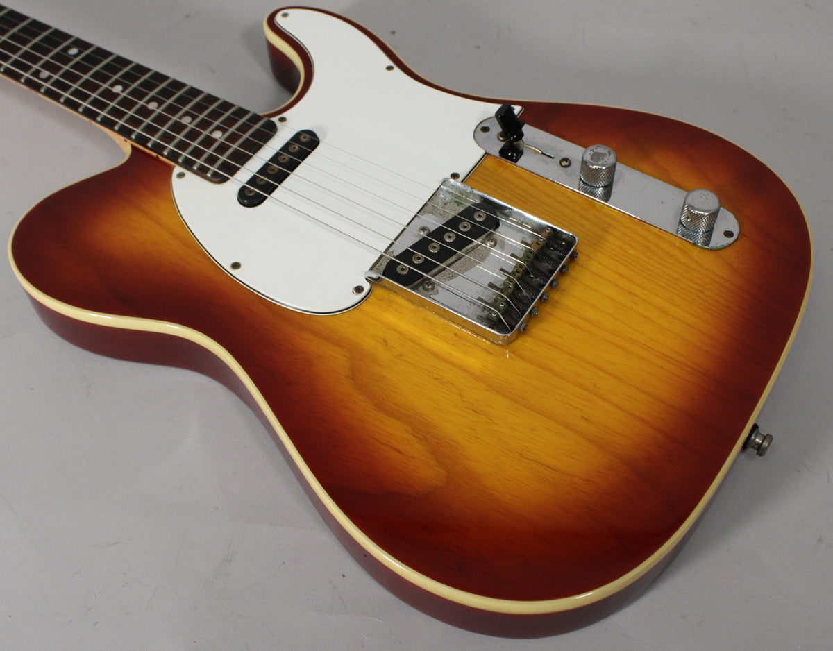 Upper body of a sunburst guitar with white binding, white pickguard, chrome bridge, and two knurled chrome knobs.