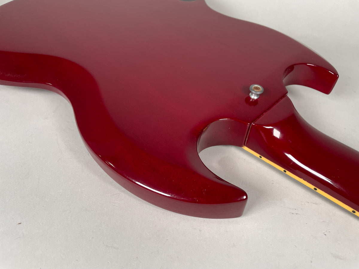 The back of a cherry red SG, showing the neck joint, strap button, and some light wear on the glossy finish.