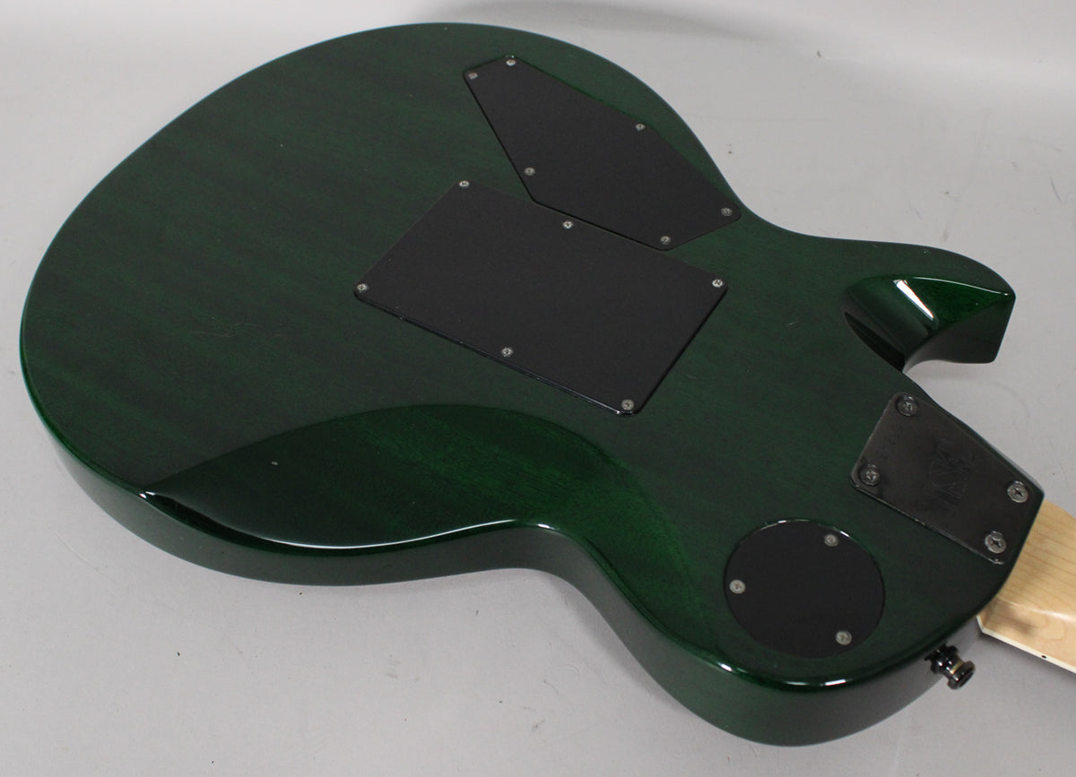 The back of a dark green electric guitar, showing two rectangular and one circular black control cavity covers.