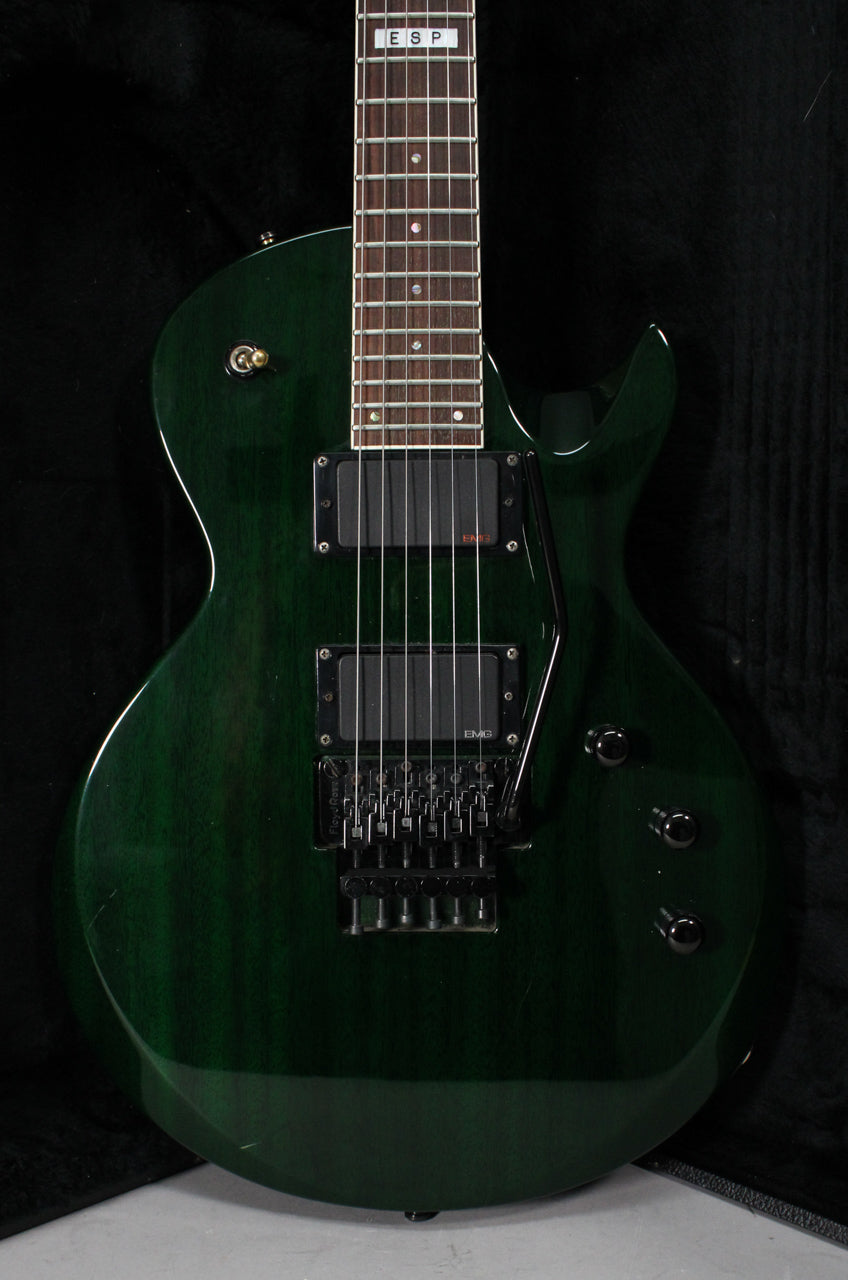 Full view of a dark green electric guitar with a Floyd Rose tremolo, two EMG humbuckers, and three black control knobs.