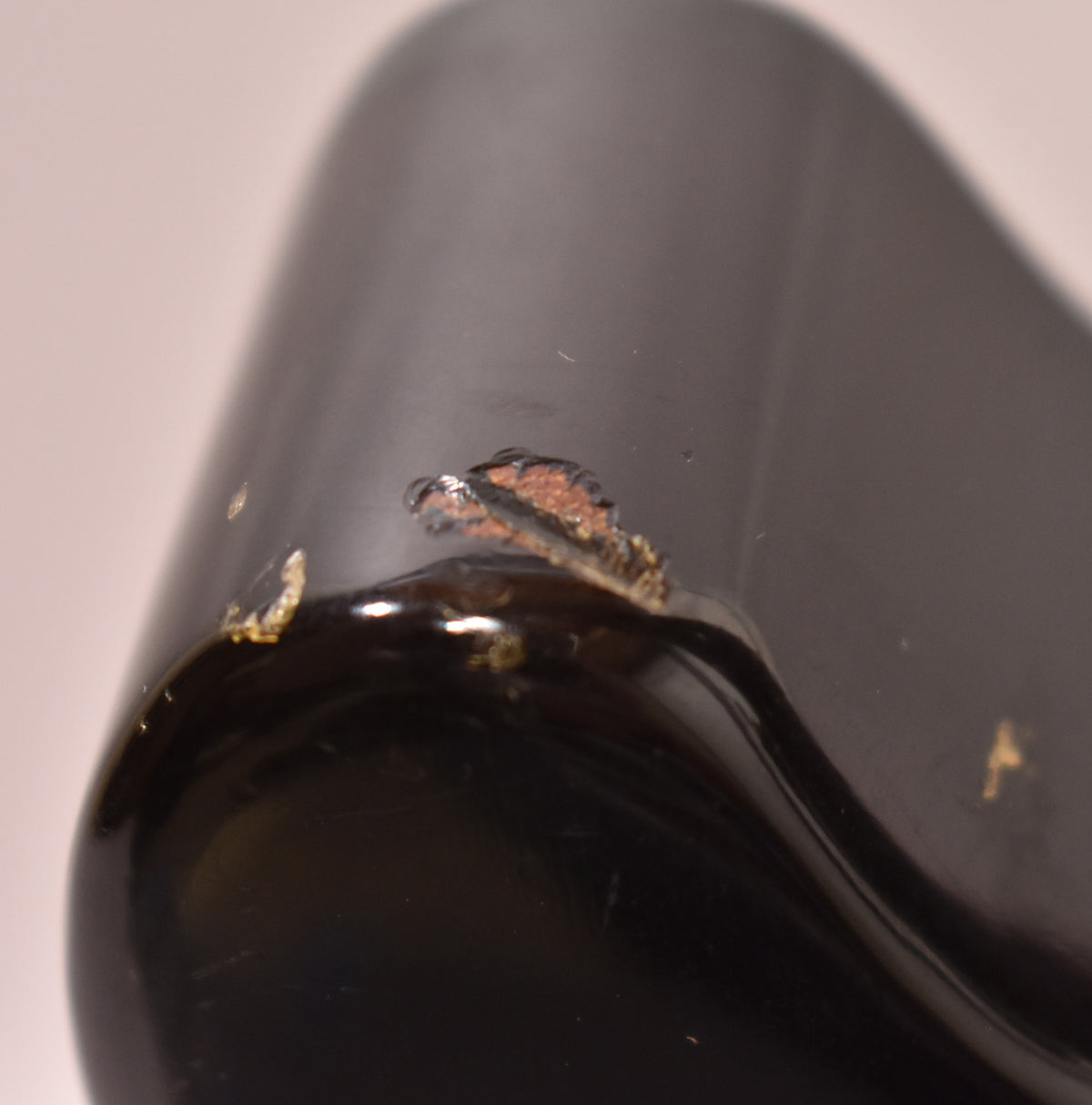 Close-up of the guitar's dark green body, showing significant paint chips and wear on the edge, revealing the wood beneath.