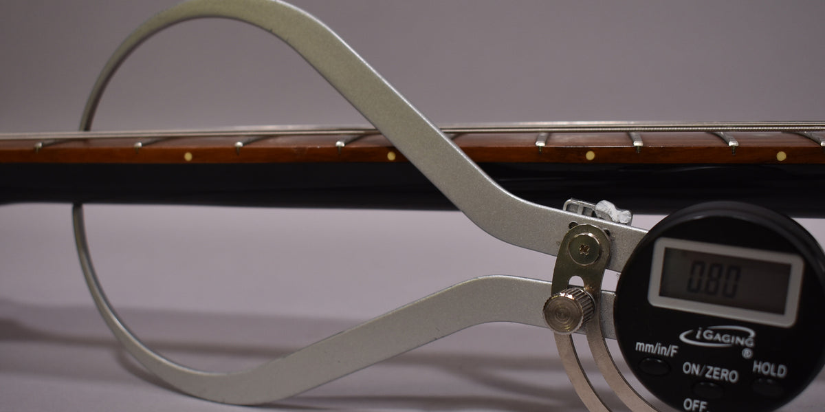 Close-up of the guitar's dark brown fretboard with small, round, light-colored inlays, showing fret height measured at 0.80mm.