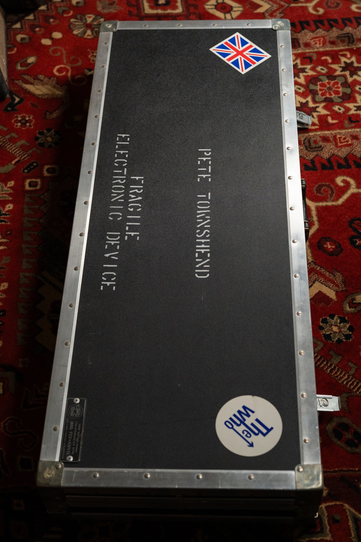 Overhead view of a black flight case with silver aluminum edges, a Union Jack sticker, and "The Who" logo.