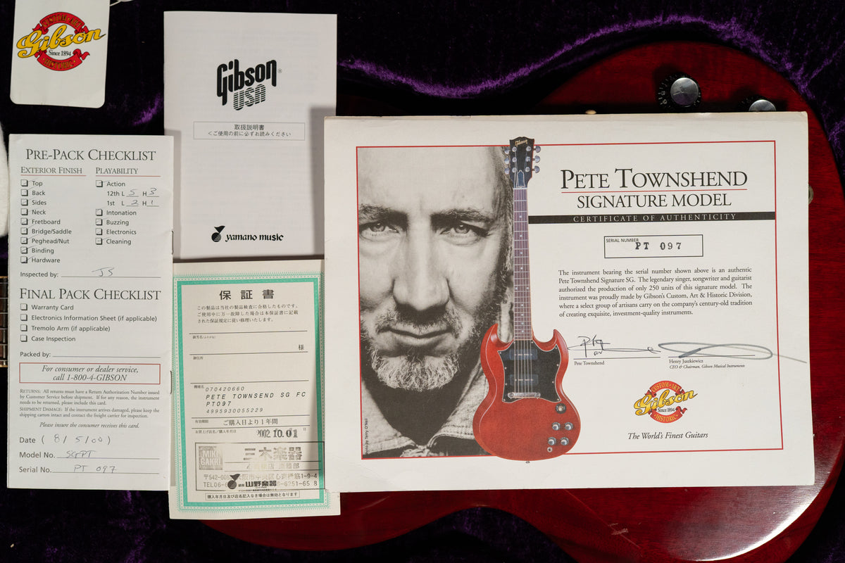 A top-down view of various white paper documents, including a certificate of authenticity with a black and white photo of Pete Townshend.