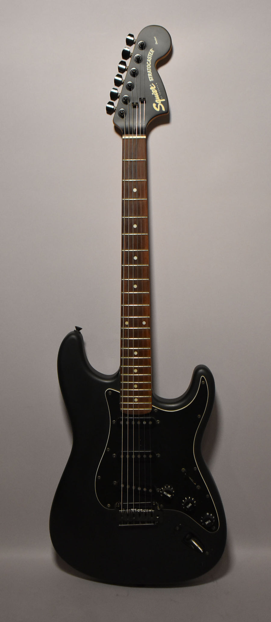 Full-length, front view of a matte black electric guitar with a dark rosewood fretboard, black pickguard, and three black single-coil pickups.