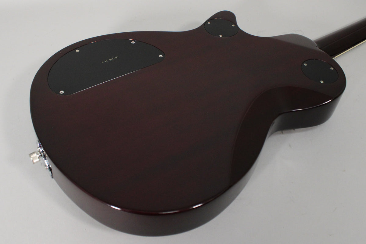 The guitar's transparent red back shows a large black control cavity cover, two smaller round covers, and a chrome output jack.