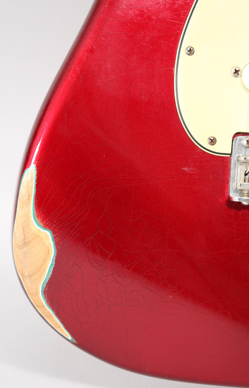 Close-up of the lower body, showing extensive finish checking, a large chip exposing wood, and a portion of the cream pickguard.