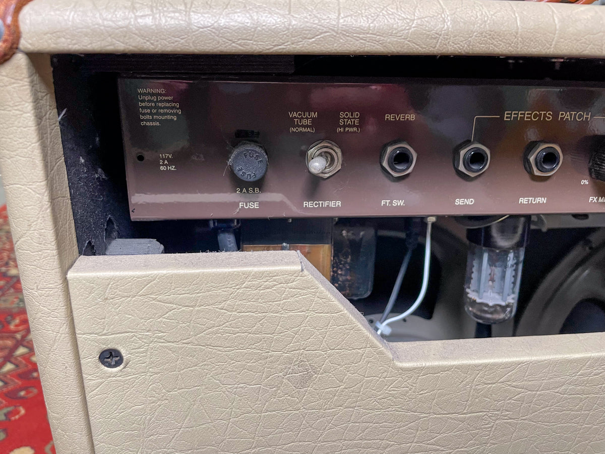 Close-up of the amp's rear brown control panel, showing a fuse, rectifier switch, and four effects patch jacks, with exposed tubes.
