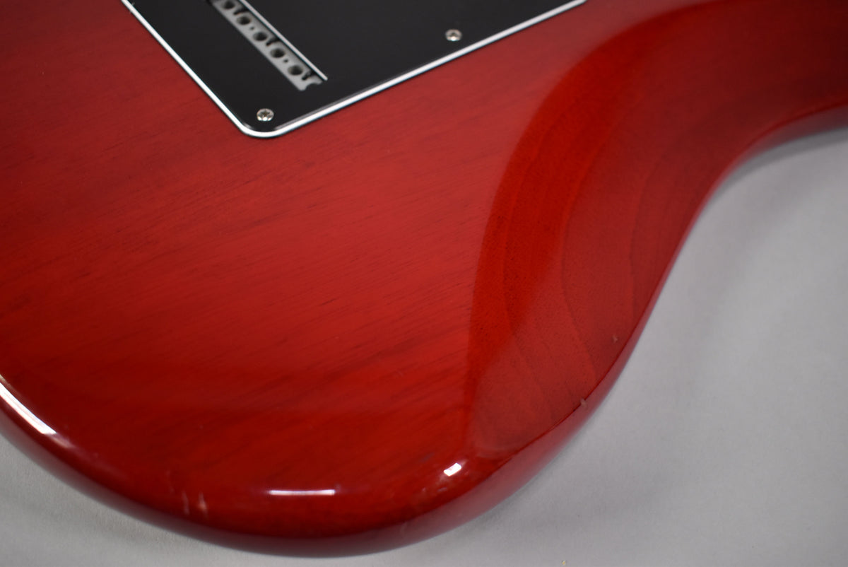 Close-up of the crimson red body, showing the black tremolo cover and subtle wear on the lower bout.