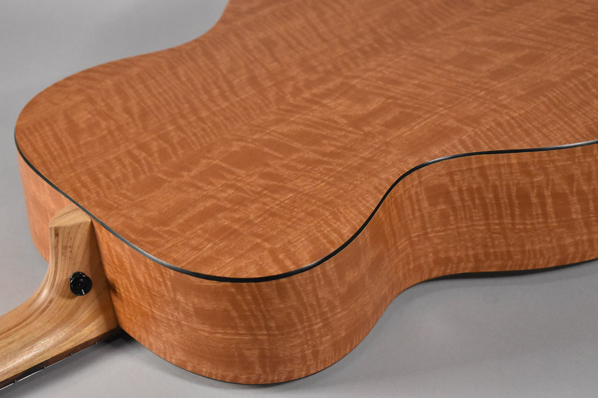 The guitar's lower bout and waist, showing the figured maple back and sides, with a black strap button on the heel.