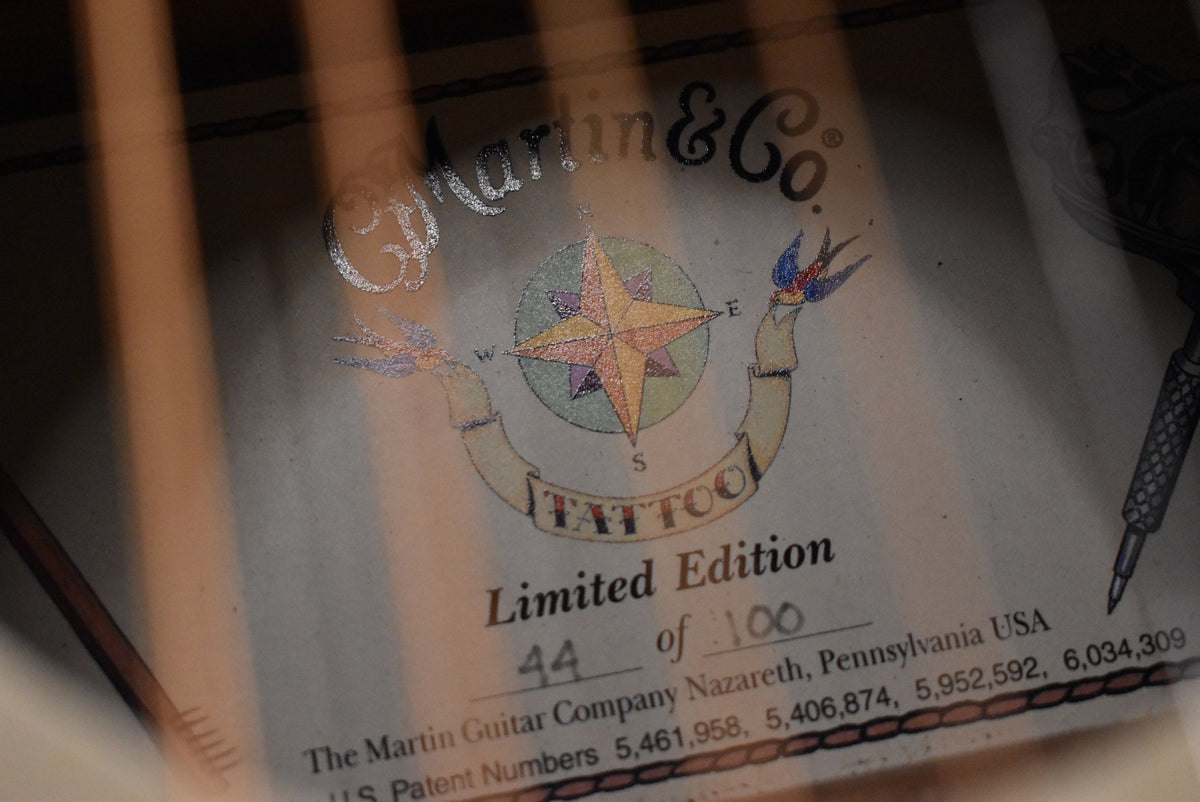 Close-up of the guitar's interior label, showing "44 of 100" in black ink, with a colorful compass rose and swallows design.