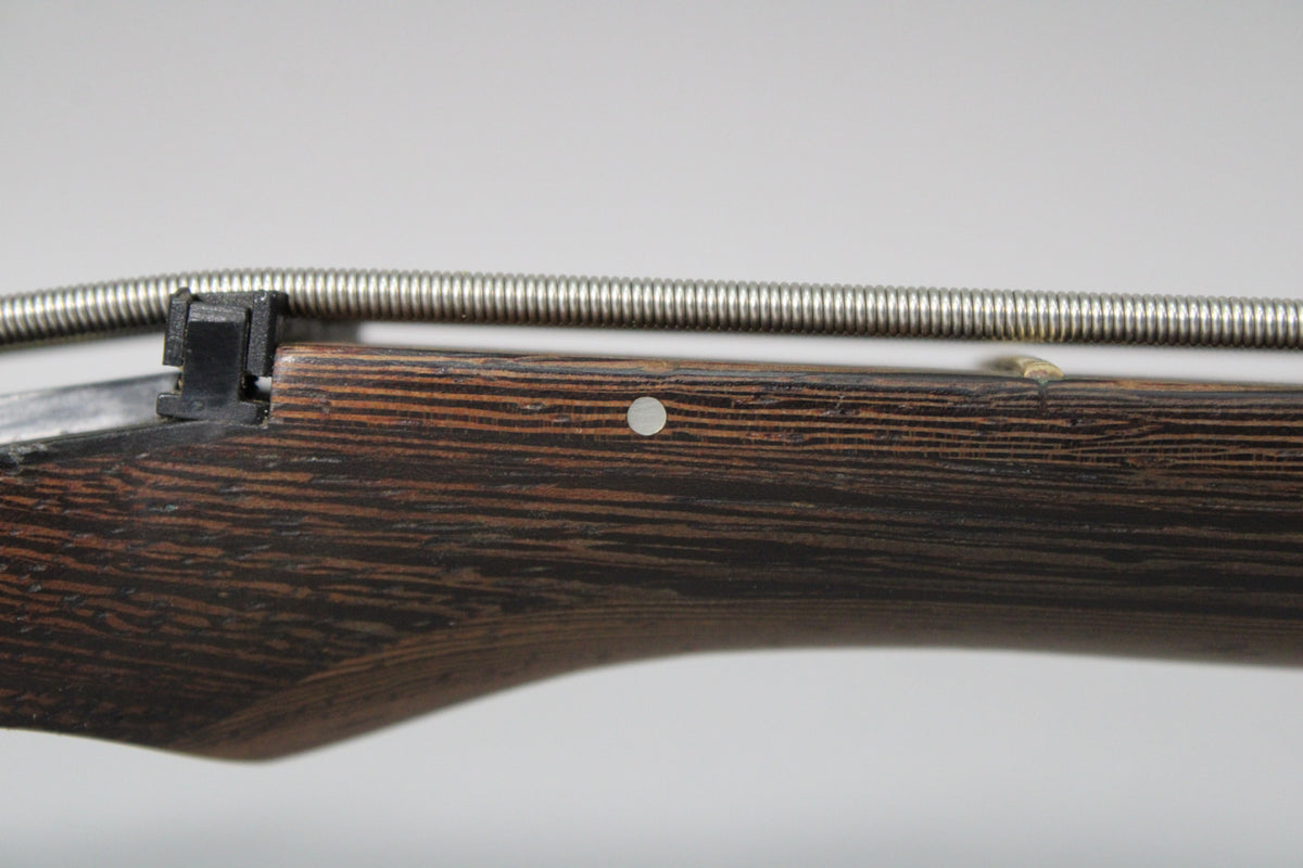 Close-up of the dark wood fretboard with a single pearloid dot inlay and a silver bass string running above.