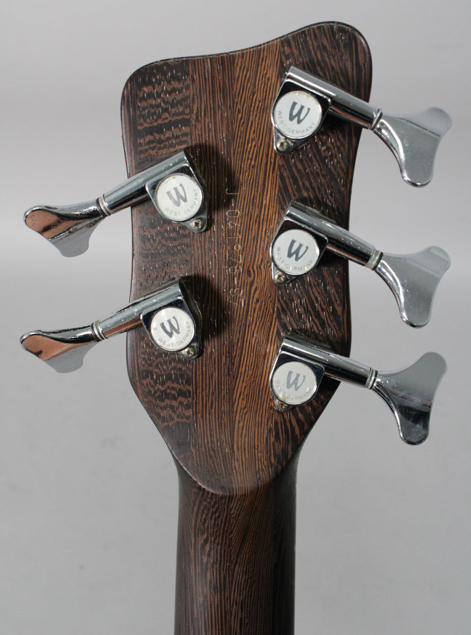 The back of a dark wood bass headstock with five chrome tuners, each marked "W WEST-GERMANY".