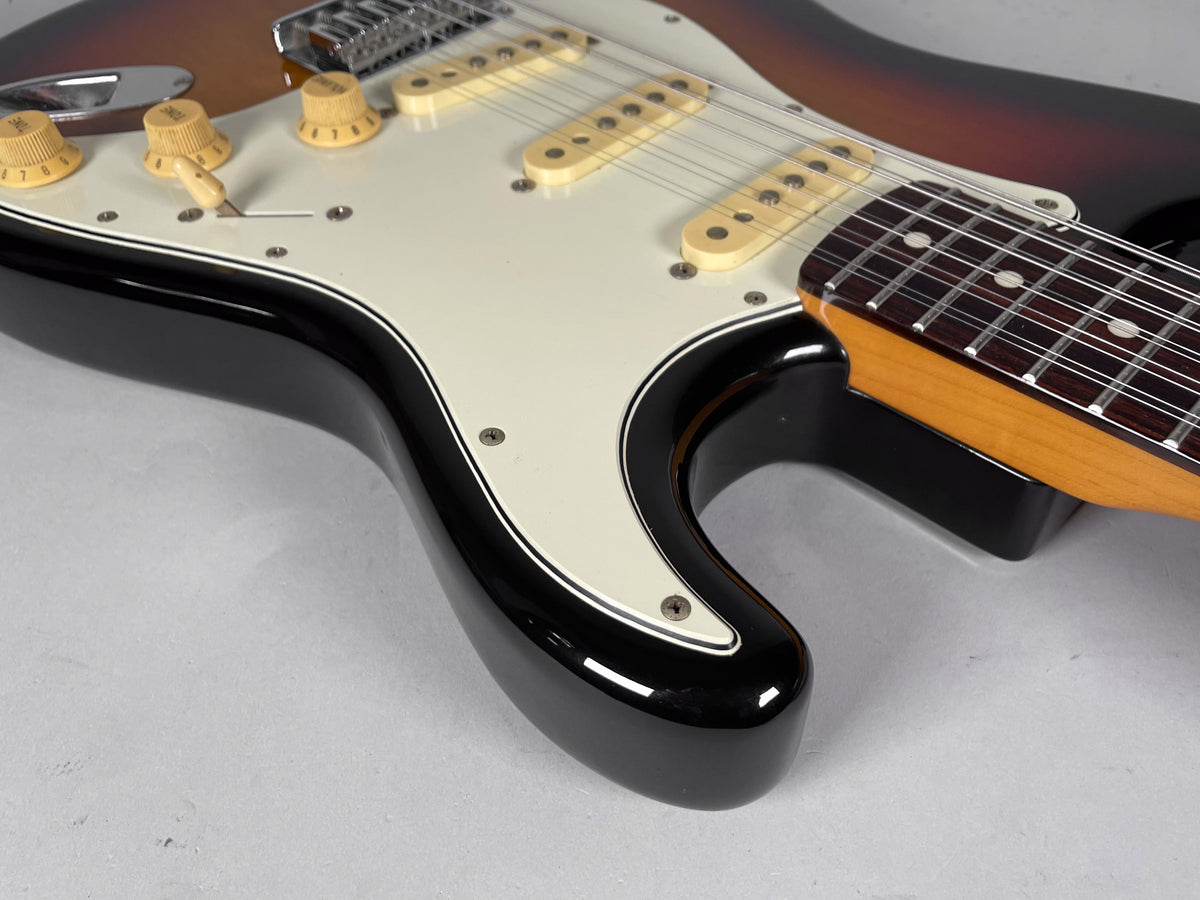 Close-up of the guitar's lower body, showing the sunburst finish, cream pickguard, three single-coil pickups, and 12-string neck.