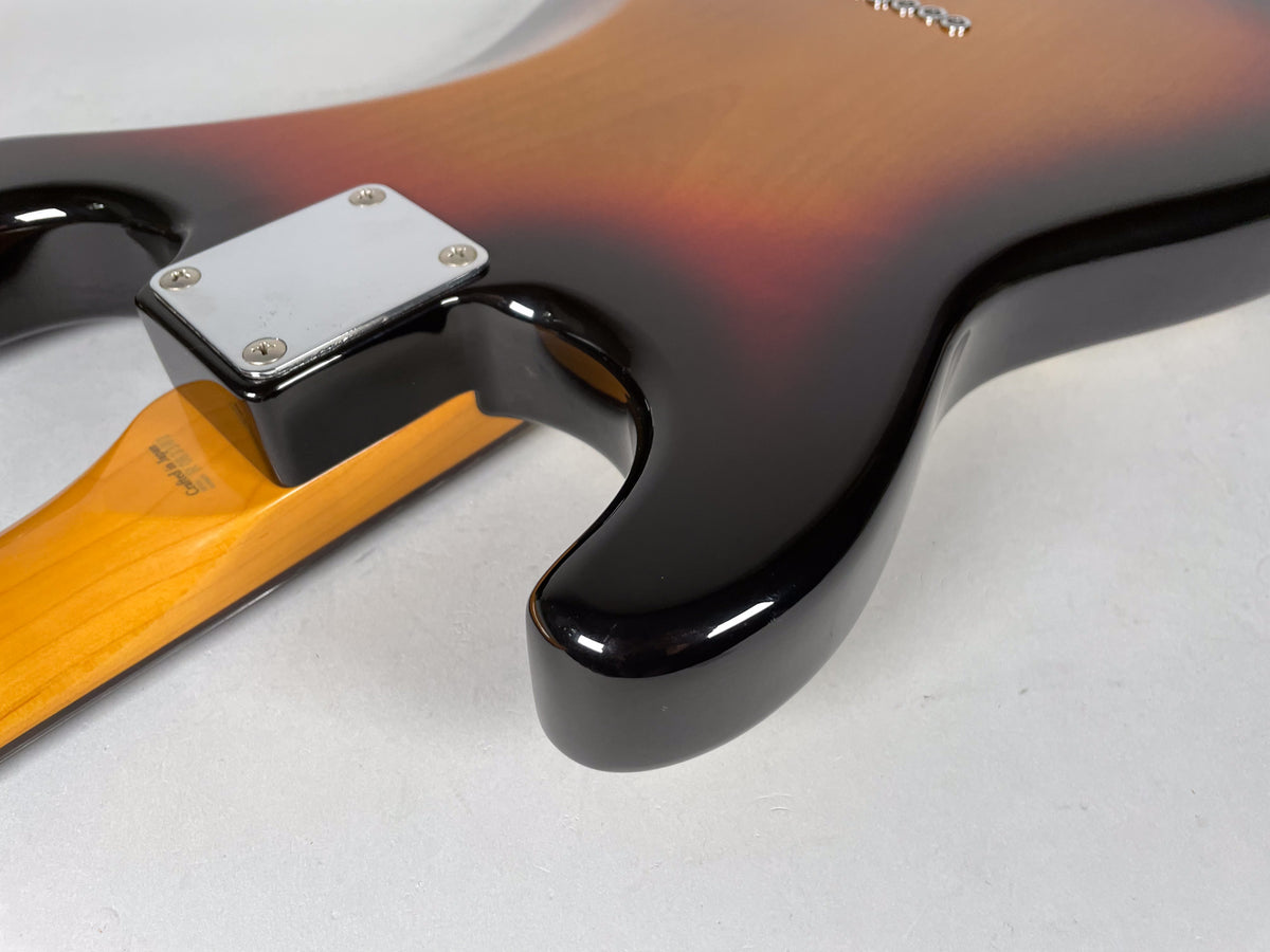The guitar's sunburst body, with a shiny finish, is viewed from the back, showing the neck joint and a chrome neck plate.