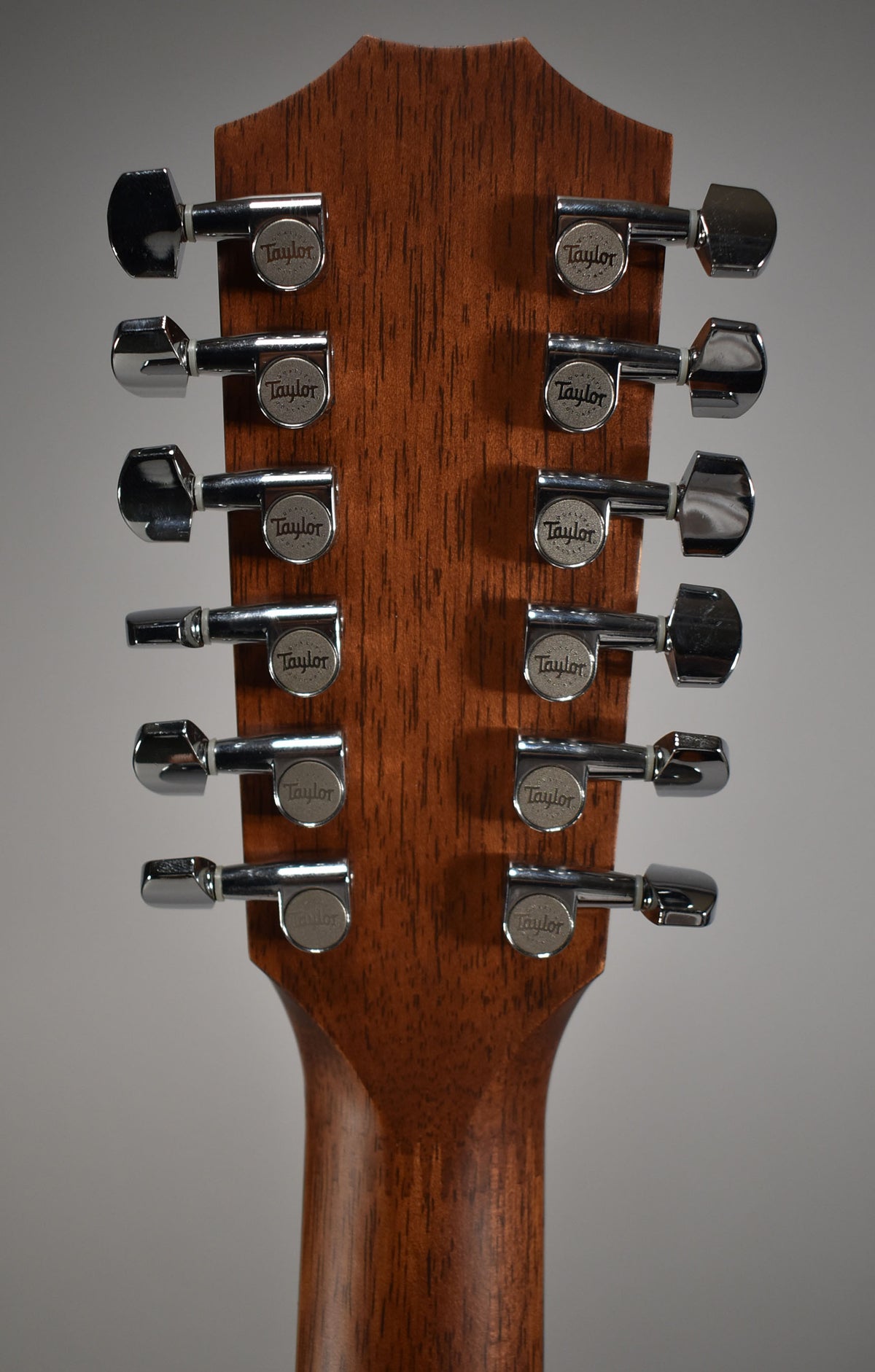 The back of a natural finish headstock and upper neck, showing twelve chrome tuners in a 6+6 arrangement.