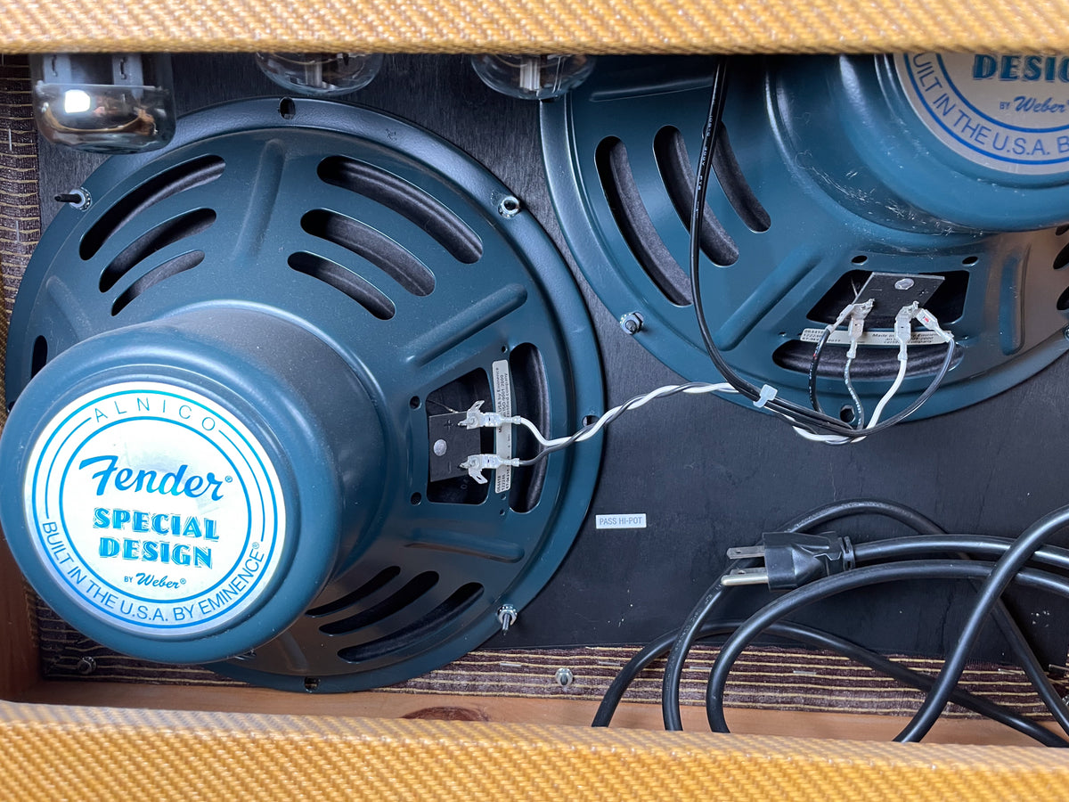 Rear view of the amp's two blue-green speakers, showing wiring, power cord, and vacuum tubes, all framed by the tweed cabinet.