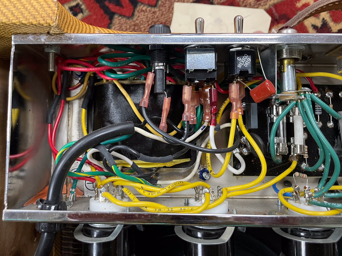 Overhead view of the amp's internal wiring, showing colorful wires, switches, and components within a metal chassis.