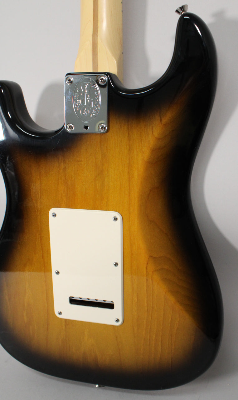 The guitar's glossy 2-color sunburst back shows a cream tremolo cover, a chrome neck plate, and a light maple neck.
