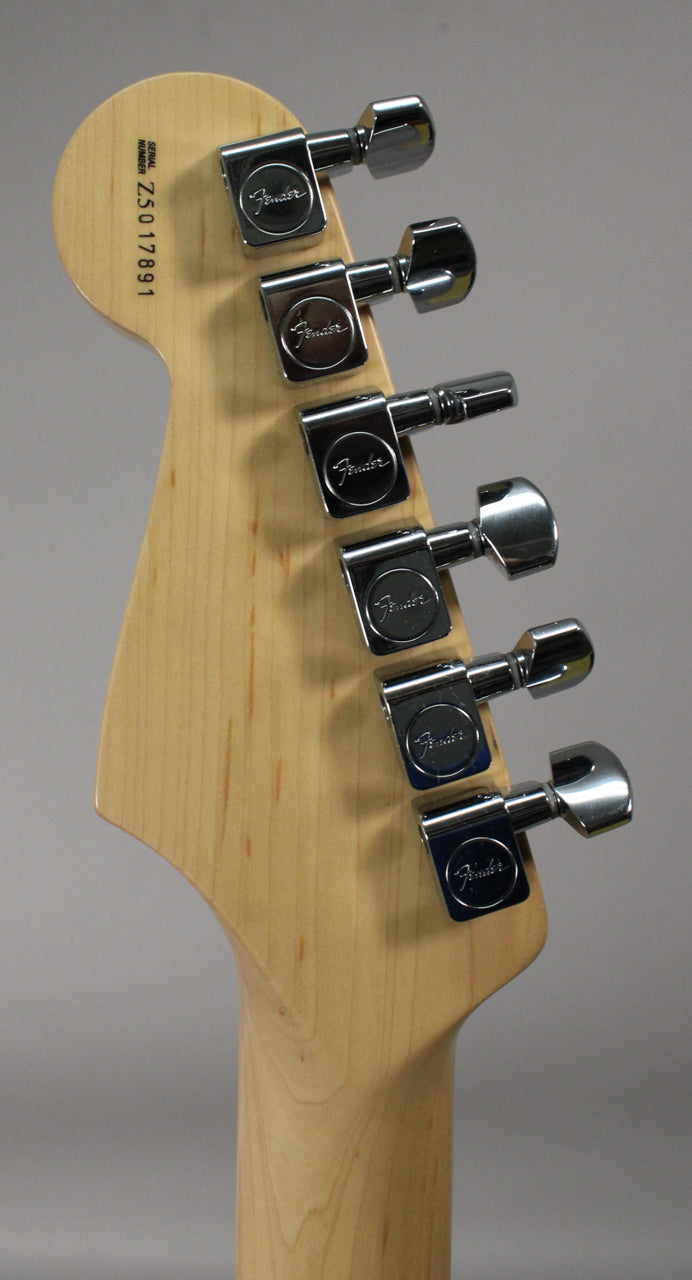 Rear view of the maple headstock and neck, showing six chrome tuners with oval buttons and a serial number stamped on the headstock.