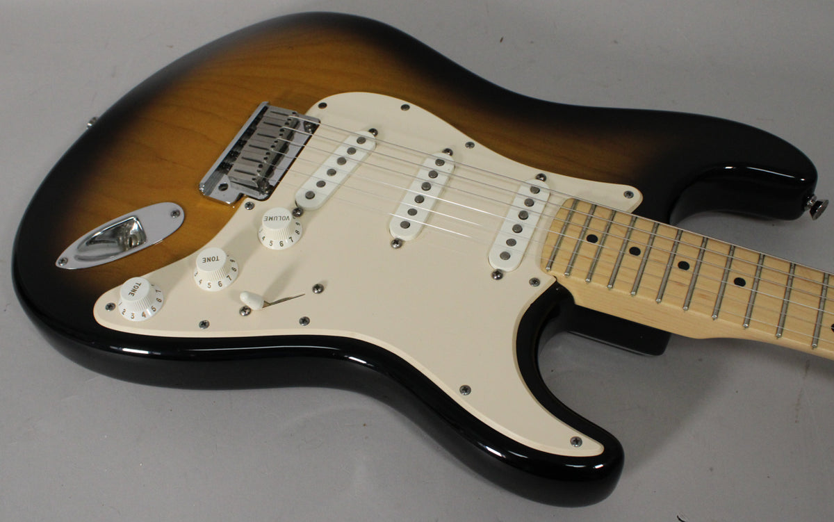The sunburst Stratocaster body is angled from the input jack to the neck, showing the cream pickguard, three single-coil pickups, and maple fretboard.