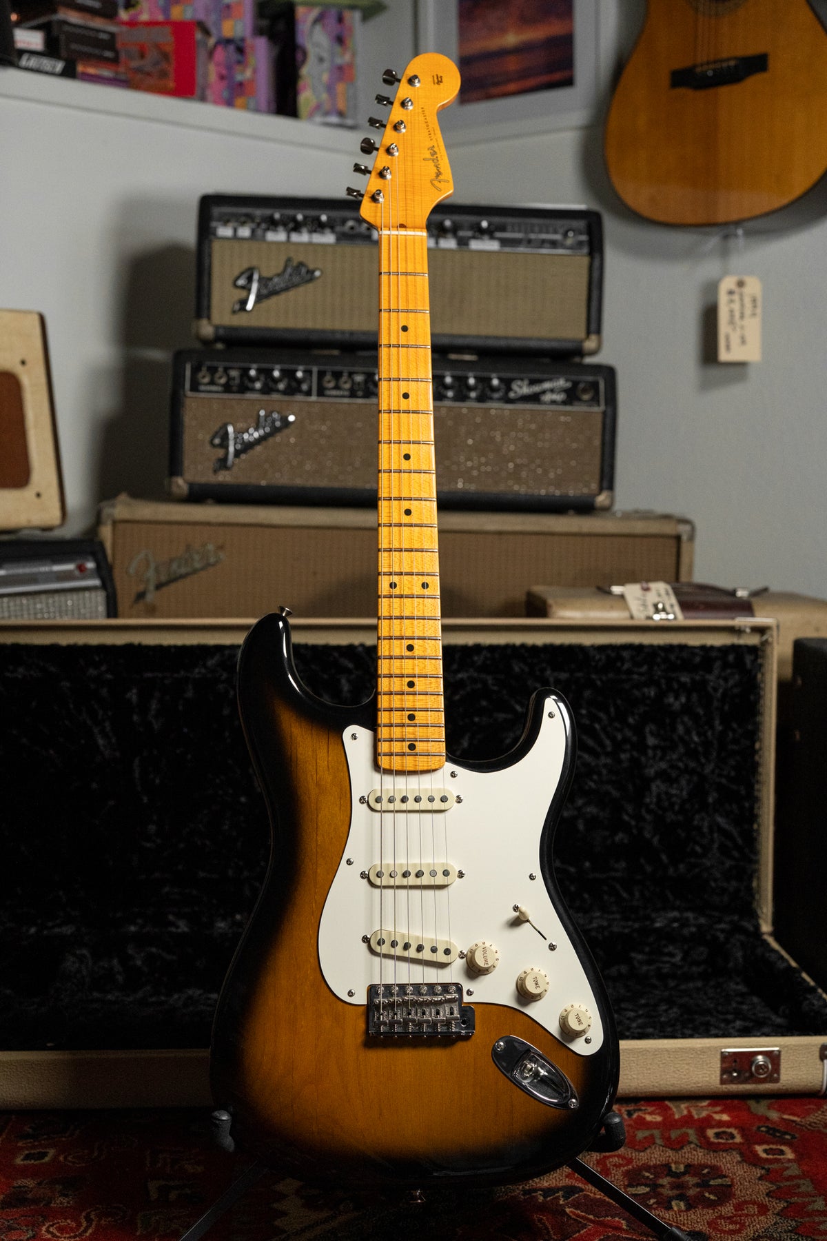 Full-front view of a glossy sunburst guitar with a white pickguard, three single-coil pickups, and a light maple neck.