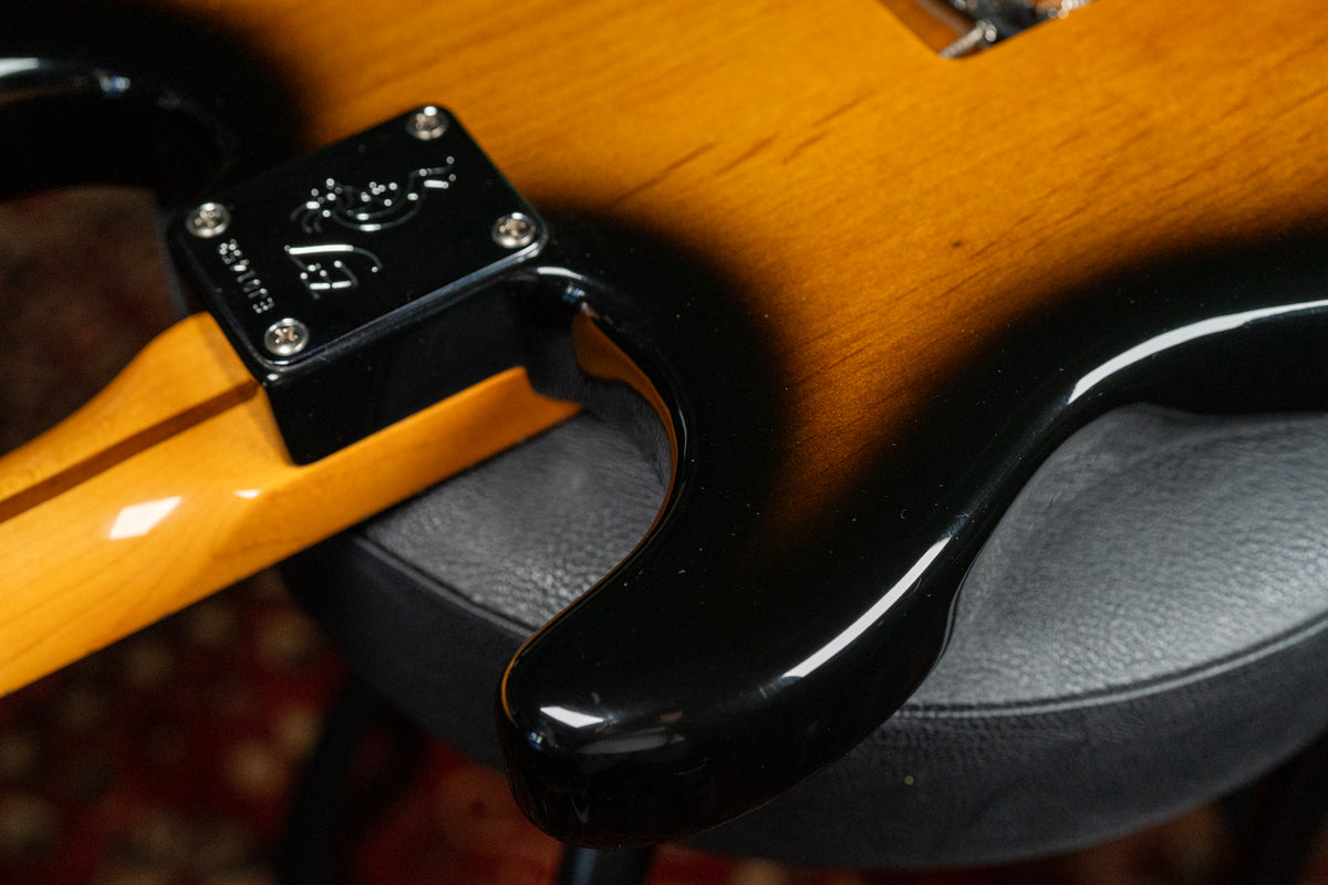 Close-up of the guitar's lower horn and neck heel, showing the glossy 2-tone sunburst finish and a black neck plate.