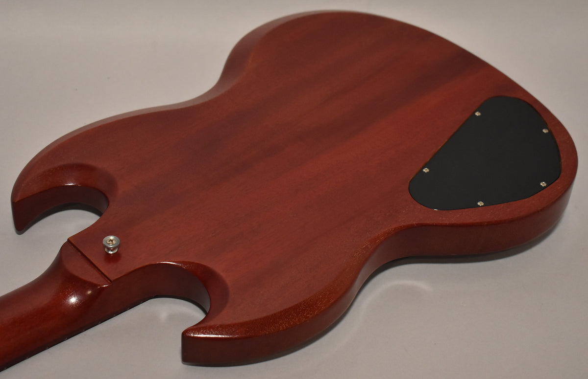 The back of the worn cherry SG shows a matte finish, a black control cavity cover, and a strap button on the upper horn.