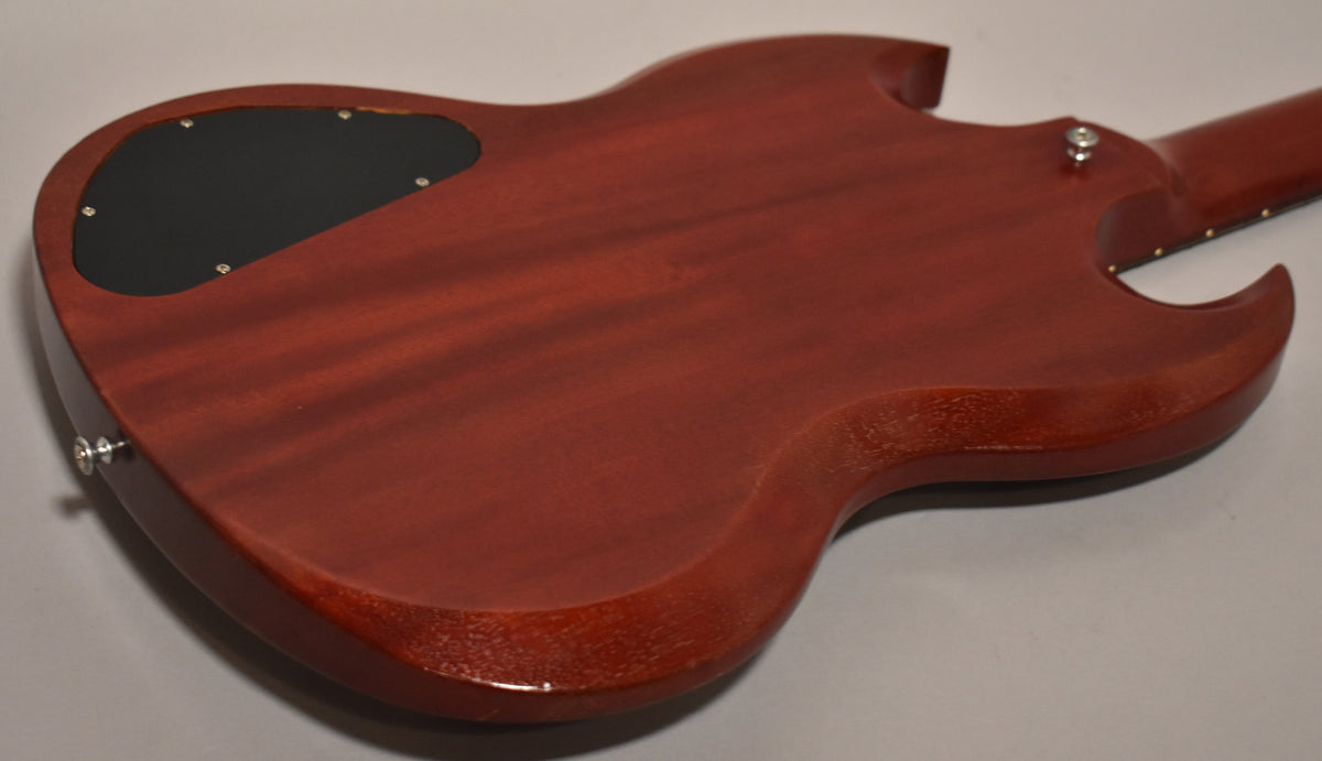 The back of the worn cherry SG shows a black control cavity cover, chrome strap buttons, and light wear on the body edges.