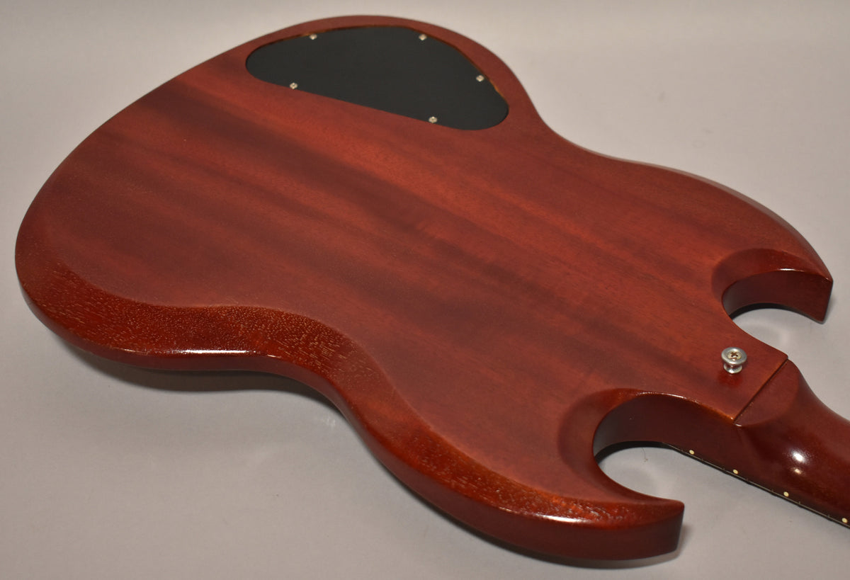 The back of the cherry red SG body, showing a black control cavity cover and finish checking on the lower bout.