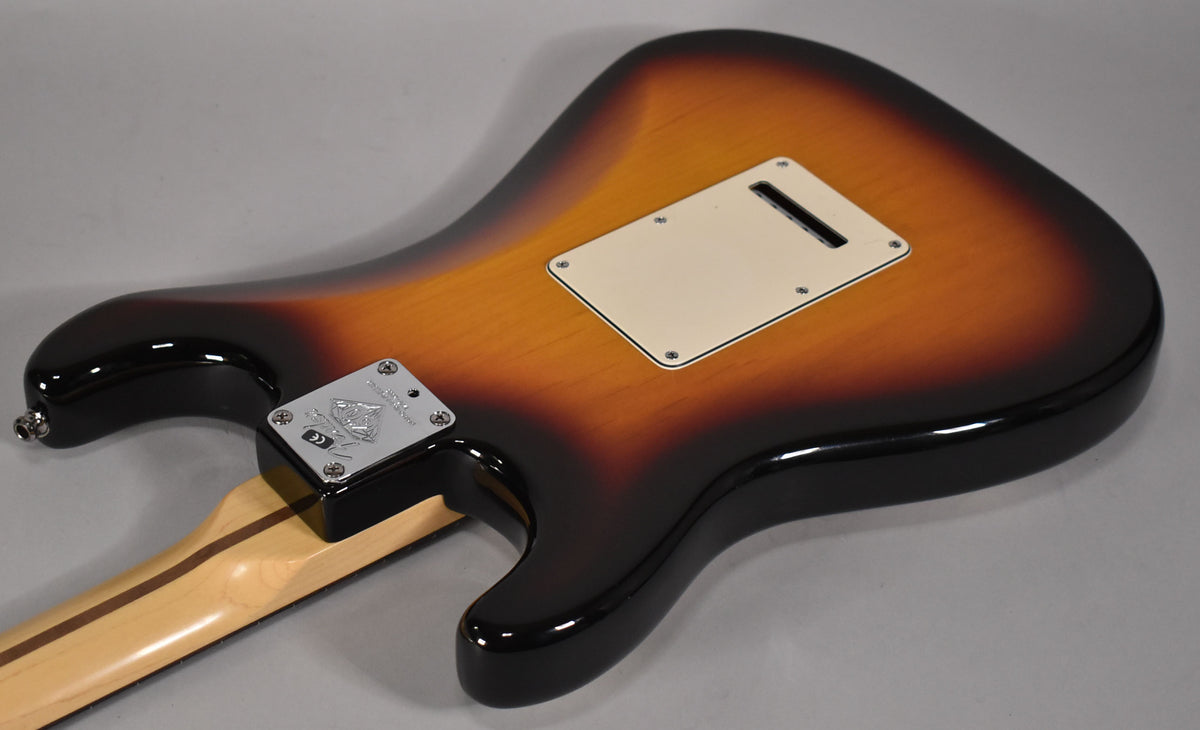 The guitar's sunburst back, with a cream tremolo cover and chrome neck plate, shows a glossy finish and no visible wear.