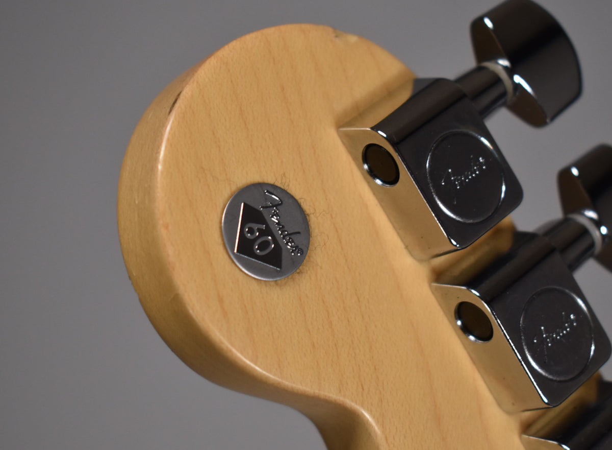 Close-up of the light wood headstock back, showing a silver 60th Anniversary medallion and three chrome tuners with light wear.