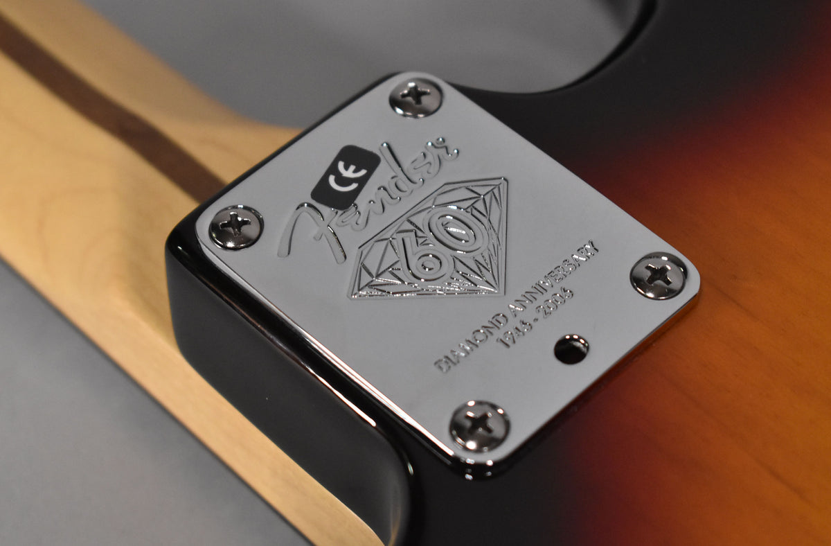 Close-up of the guitar's chrome neck plate, engraved with "60 Diamond Anniversary 1946-2006," attached with four screws.
