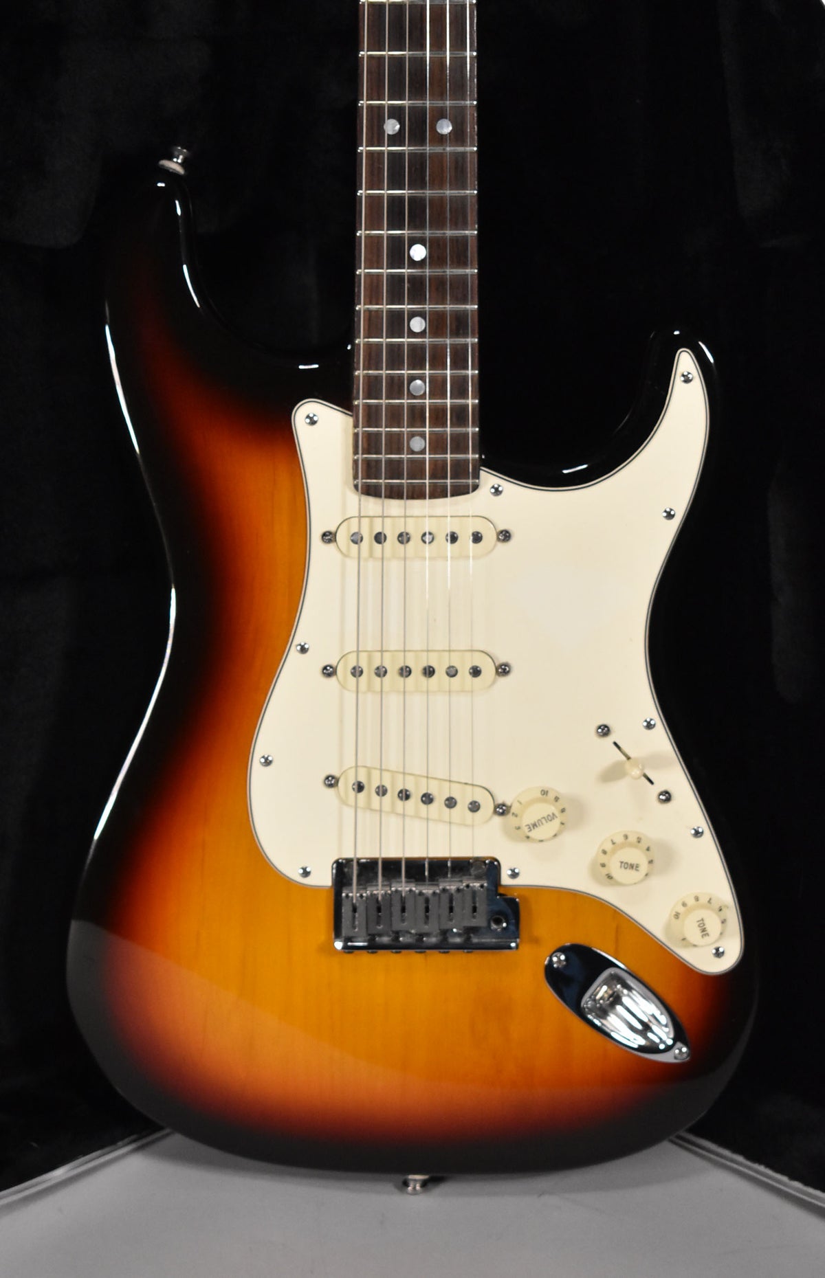 Full-body shot of a glossy sunburst Stratocaster with a cream pickguard, three single-coil pickups, and chrome hardware.