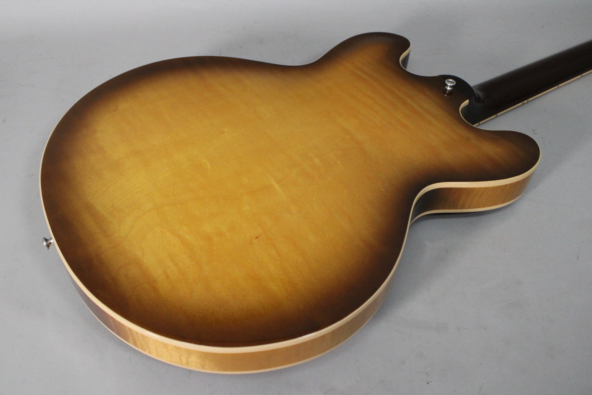The back of the sunburst semi-hollow guitar, showing the figured maple grain and a strap button on the upper horn.