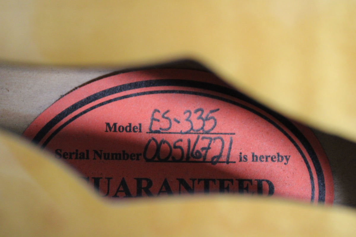 A close-up of the guitar's interior label, red with black text, showing "Model ES-335" and "Serial Number 00516721".