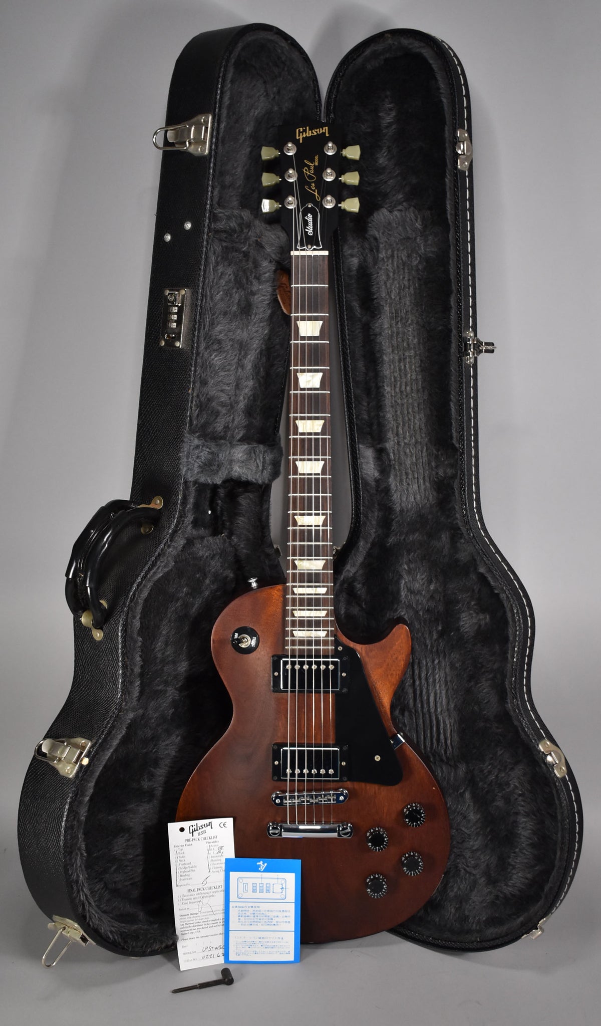 Full-length view of a faded walnut Les Paul Studio with black hardware, resting in its open, black fur-lined hard case.