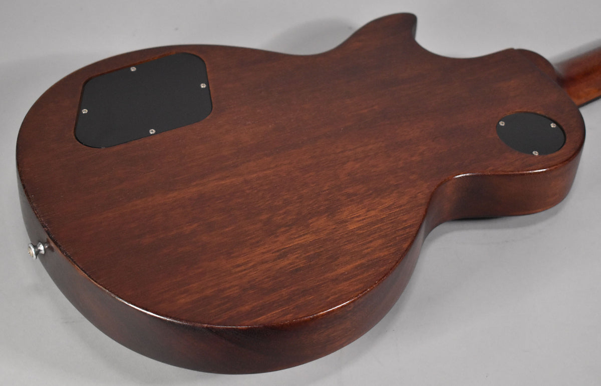 The back of the faded walnut guitar body, showing the large rectangular control cavity cover and the smaller round jack plate.