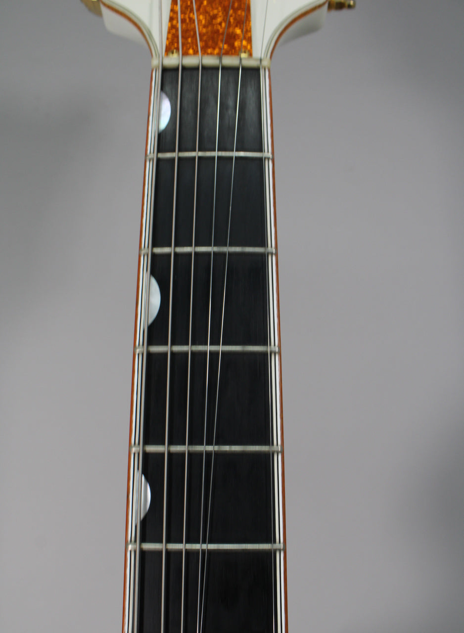 Close-up of the dark fretboard with white binding, mother-of-pearl half-moon inlays, and a gold sparkle headstock overlay.