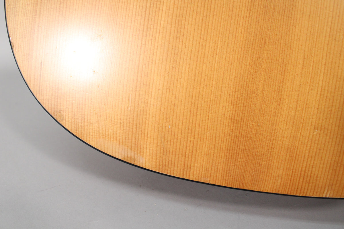 Close-up of the lower bout of the light-colored satin mahogany body, showing a few small dings and scuffs near the black binding.