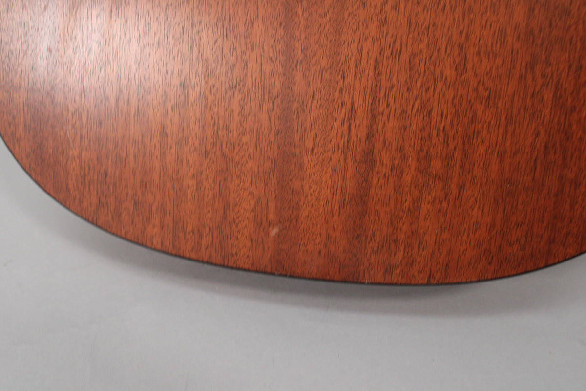 Close-up of the guitar's lower bout, showing the reddish-brown satin mahogany finish with a small ding near the bottom edge.
